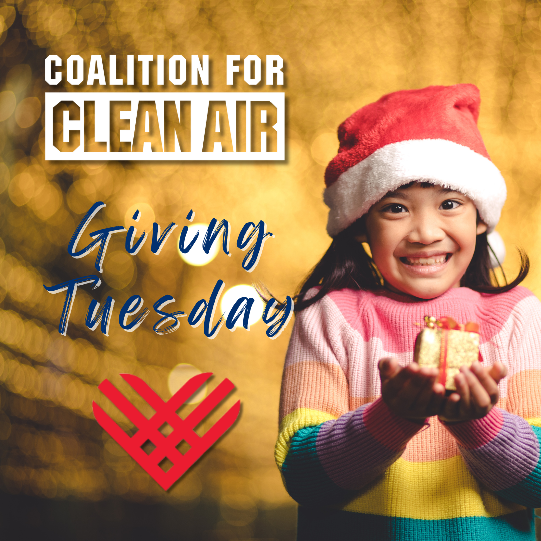 A happy child wearing a Santa hat and a colorful striped sweater holds a small, 